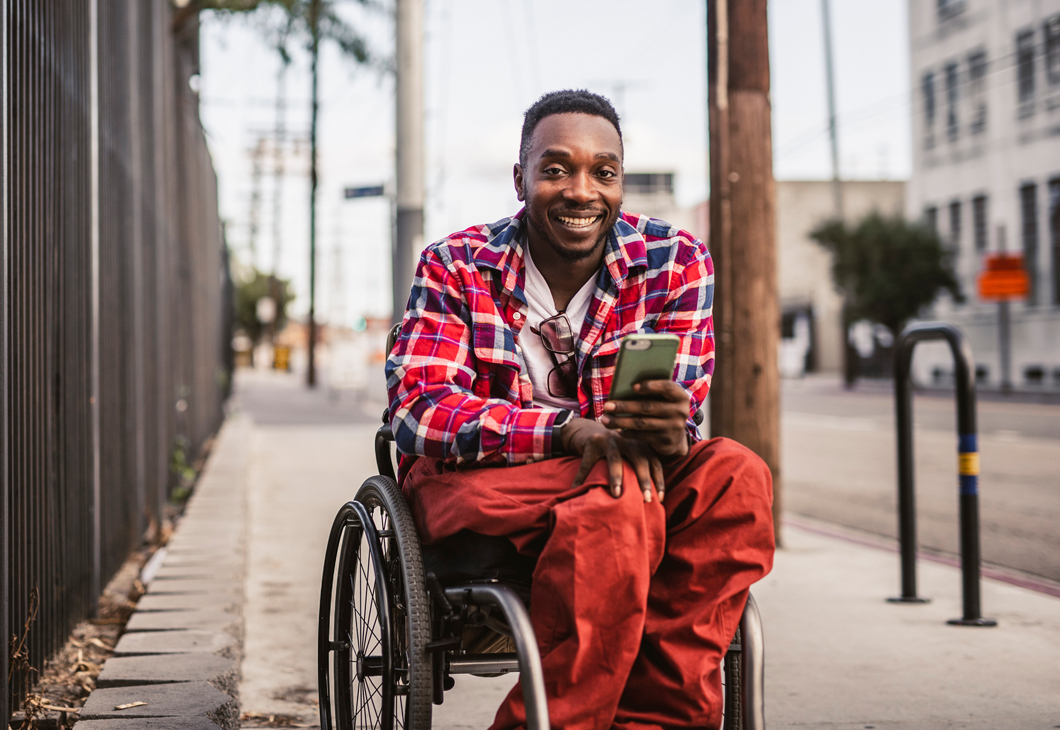 Photo of a man in a wheelchair smiling.