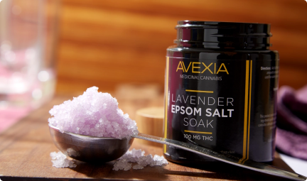 Photo of epson salt soak in a spoon next to an open jar o the product